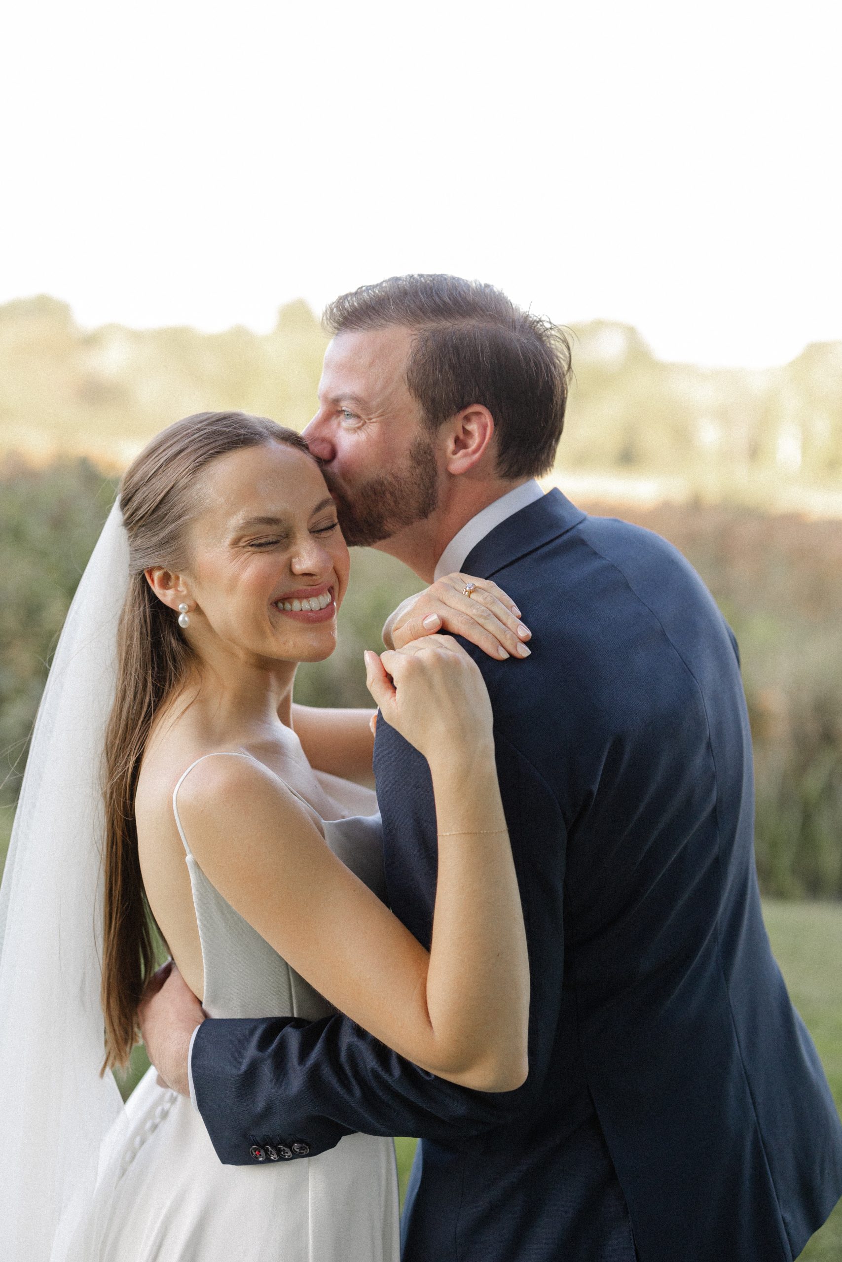 Natural bridal makeup on bride hugging groom
